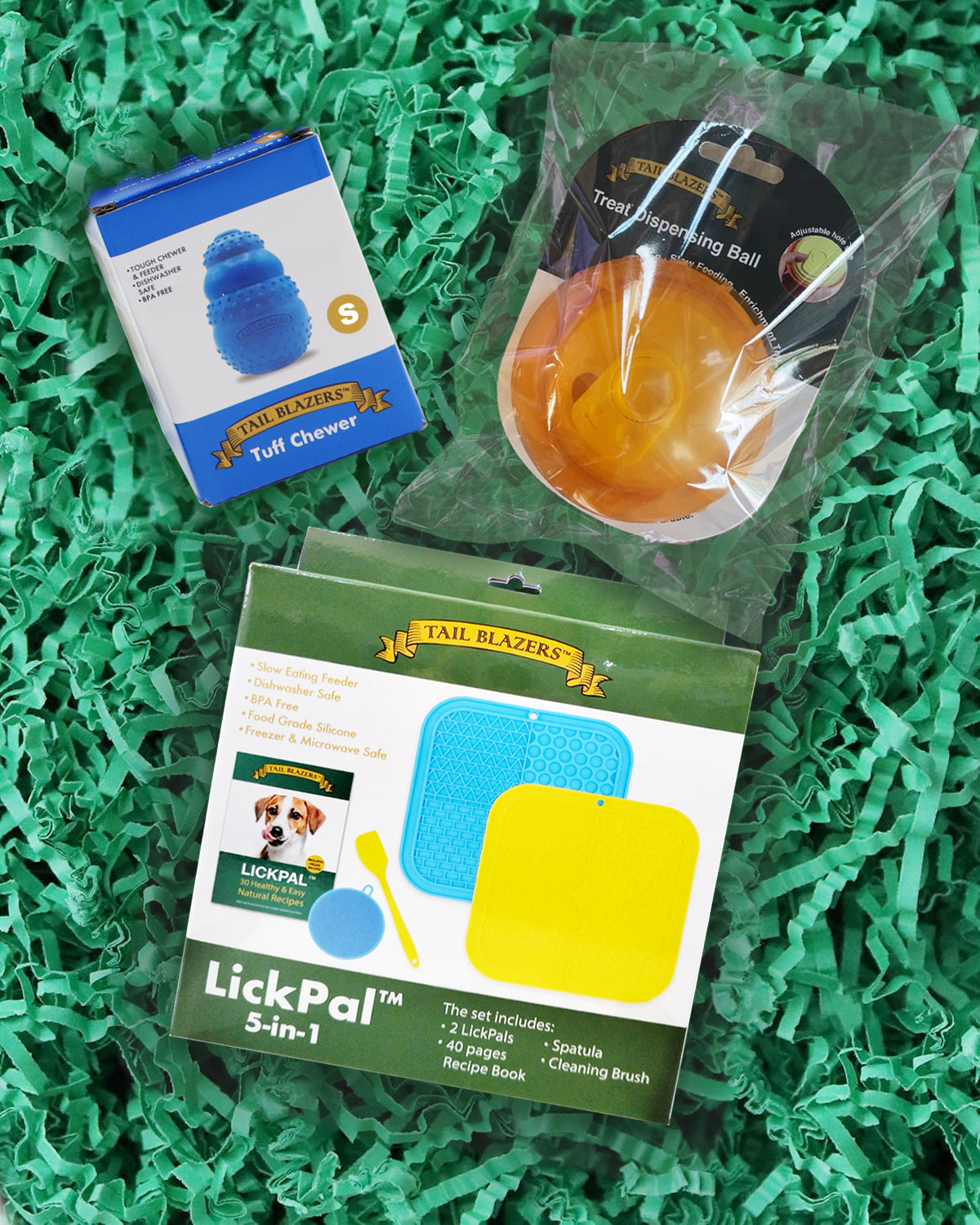 Dog enrichment set with a rubber chewer, 5 in 1 lick mat set and a Treat ball on the packaging shredded paper background