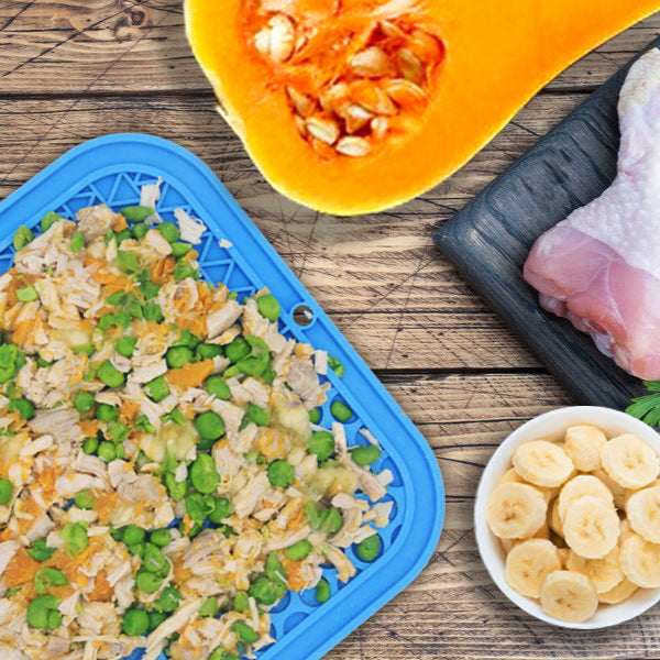 Prepared food items including chicken legs, vegetables, and a dish of rice with peas on a wooden surface.